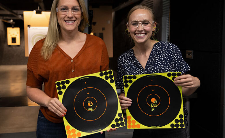 two people holding up targets and smiling
